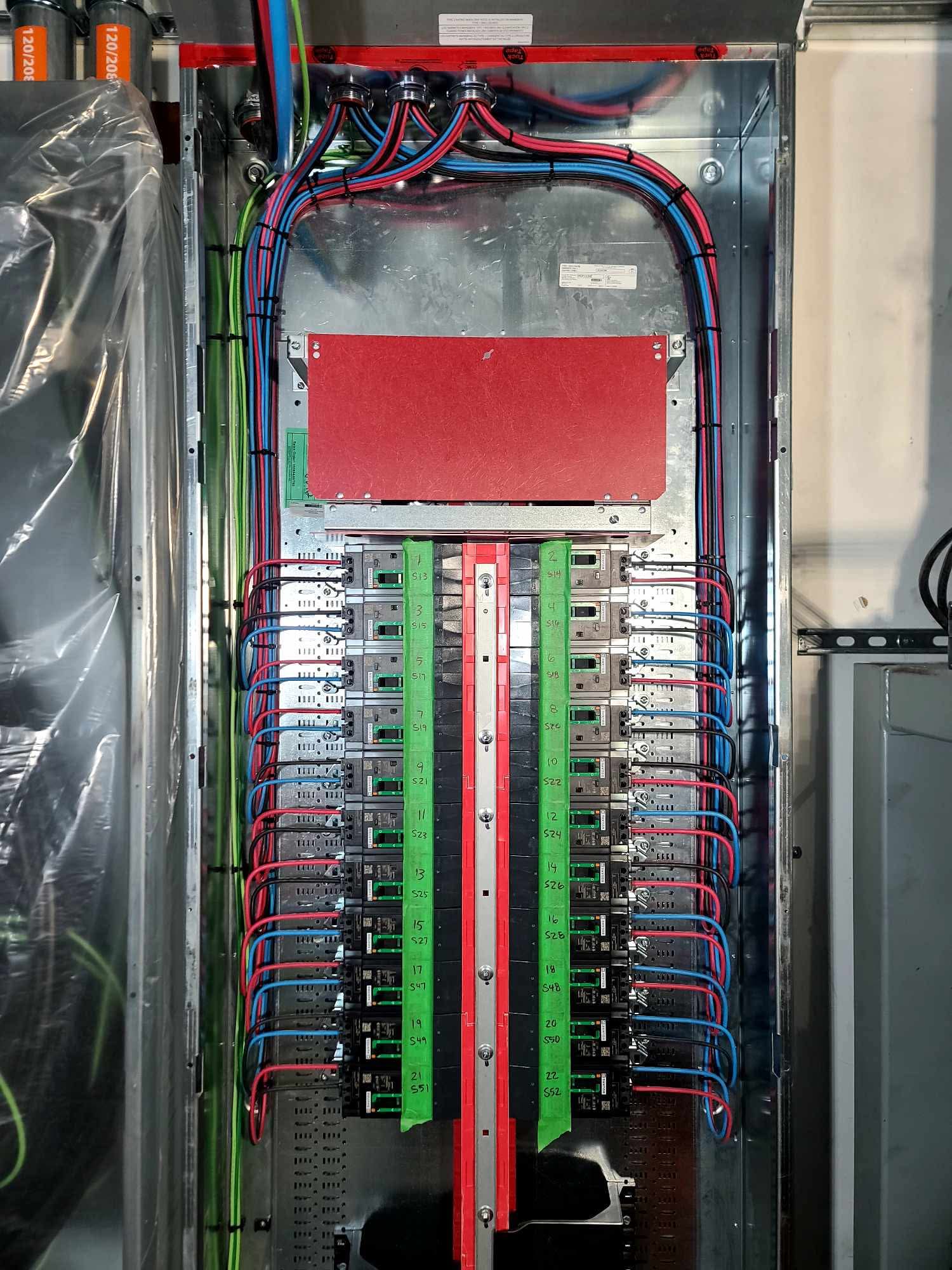 Neatly installed branch circuit panel with red center divider and uniform conductors