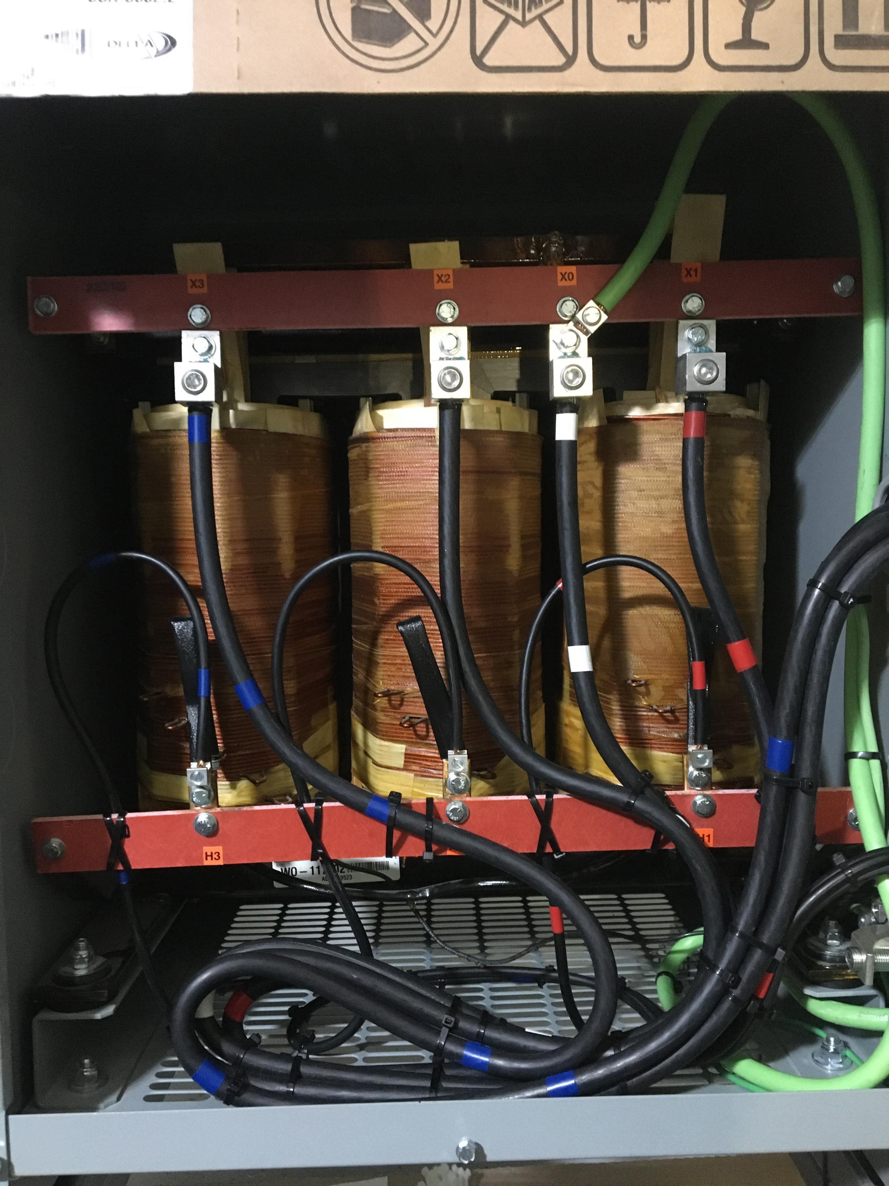 Close-up of three transformer windings with terminations and labels